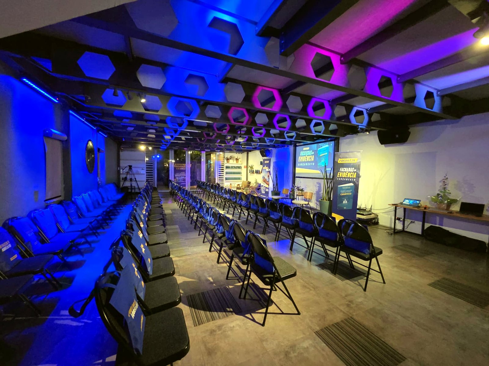 Evento de lançamento com iluminação cênica azul no salão