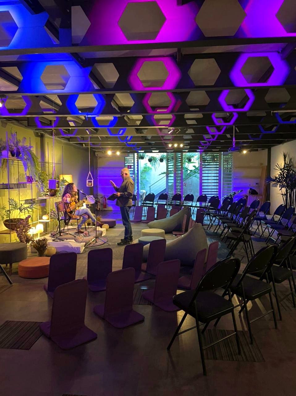 Show acústico no salão com iluminação colorida e almofadas