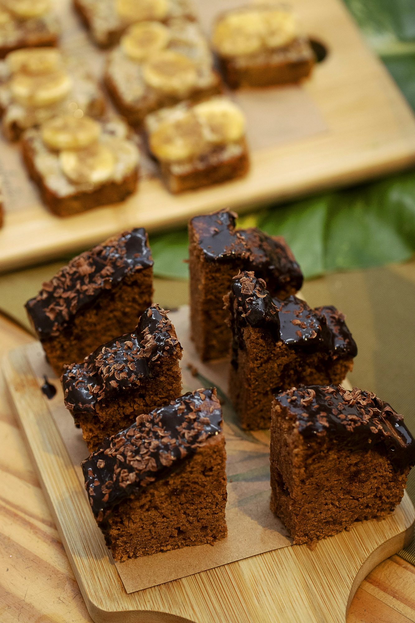 Fatias de bolo de chocolate com ganache e nibs de cacau sobre tábua